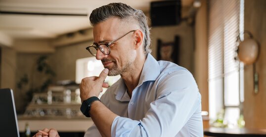 European grey man working with papers and laptop at office