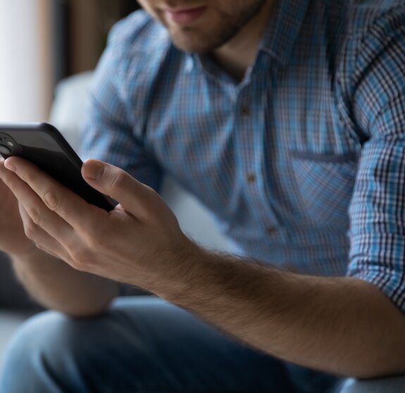 Hands of man using online virtual app on mobile phone. Millennial guy chatting on smartphone, using banking services, reading text message, typing, shopping, making call, browsing internet. Close up