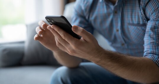 Hands of man using online virtual app on mobile phone. Millennial guy chatting on smartphone, using banking services, reading text message, typing, shopping, making call, browsing internet. Close up