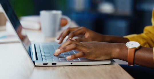 Close up shot of female hands typing on laptop