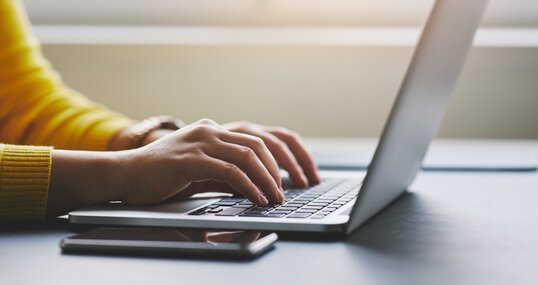 Close up of female hands while typing on laptop