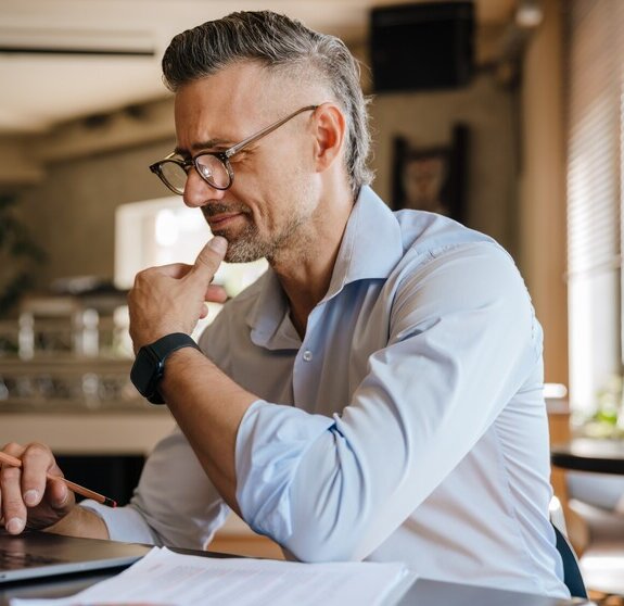 European grey man working with papers and laptop at office