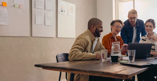 Cheerful business colleagues watching a presentation on a laptop