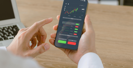 Businessmen work with stock market investments using smartphones to analyze trading data. smartphone with stock exchange graph on screen. Financial stock market