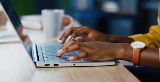 Close up shot of female hands typing on laptop