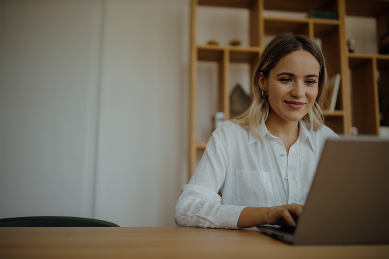 Young beautiful woman working on laptop at home office, copy space, portrait.