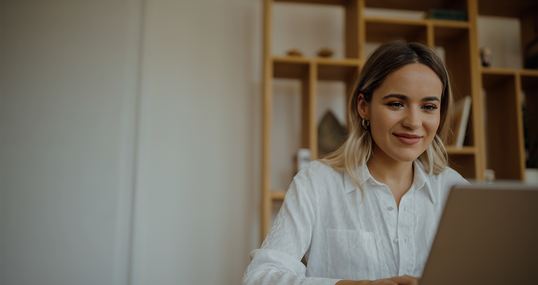 Young beautiful woman working on laptop at home office, copy space, portrait.