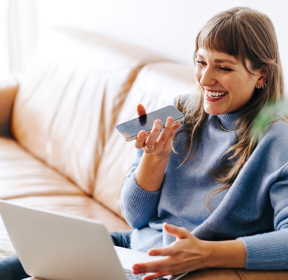 Happy young businesswoman having a phone call discussion in an office