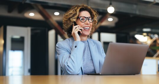 Business woman talking on a phone call in a coworking office