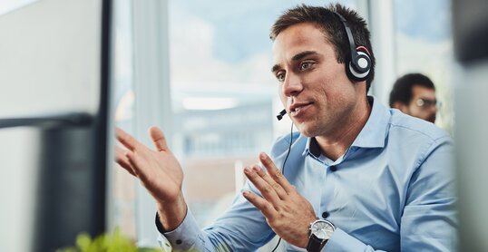 Businessman, call center and consulting on computer in customer support, service or telemarketing at office. Man employee, consultant or agent talking on PC for online advice or help in contact us