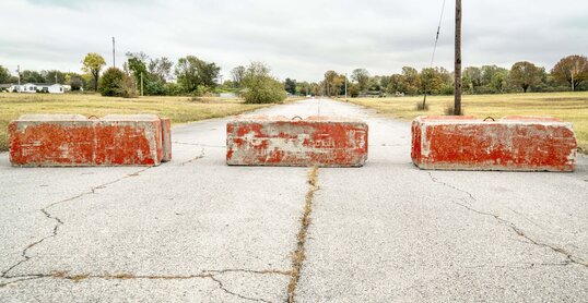 Rote Zementblöcke, die auf einer Straße eine Barriere bilden.