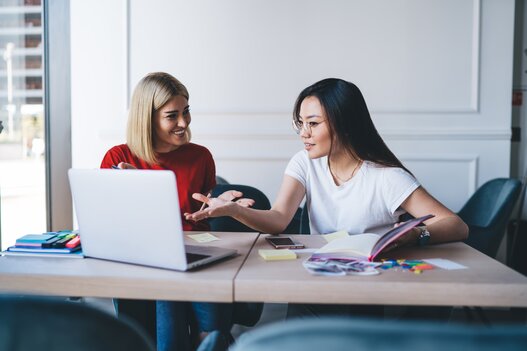 Multiethnic women working with laptop in office