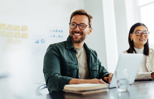 Happy business man listening to a discussion in an office