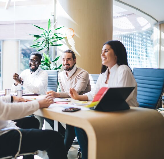 Cheerful diverse colleagues gathering on meeting in office