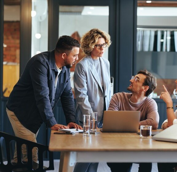 Gruppe von Geschäftsleuten in einer Besprechung vor einer SharePoint Site