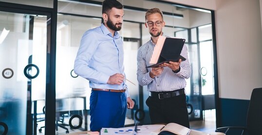 AdobeStock, zwei Männer im Büro im Austausch