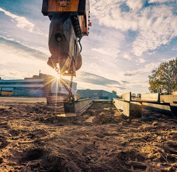 Bagger auf Baustelle bei Sonnenaufgang